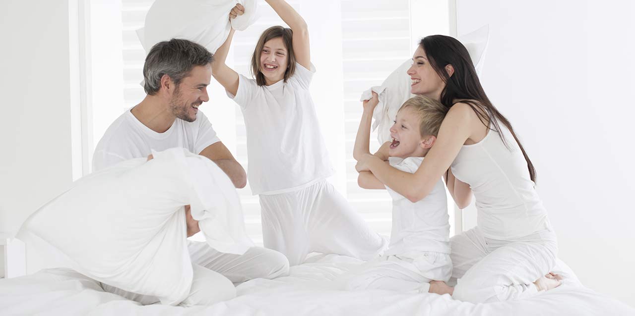 família a brincar com almofadas