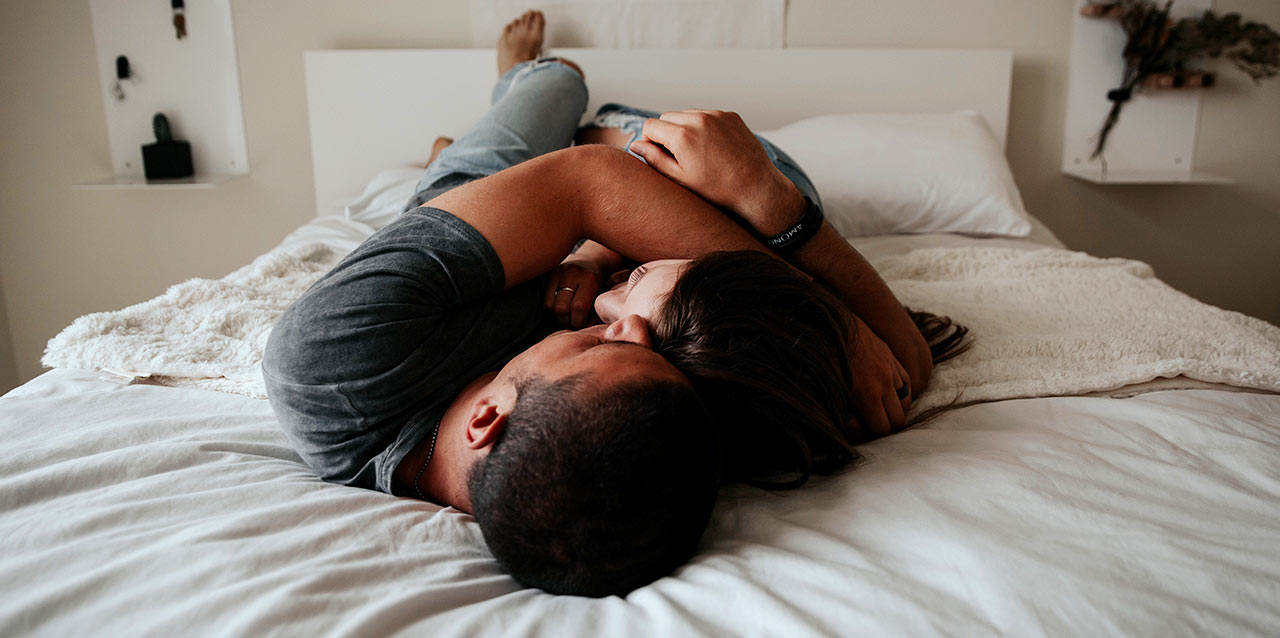 casal abraçado deitados em colchão