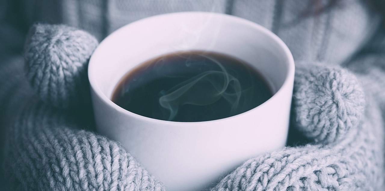 café quente em mãos com luvas