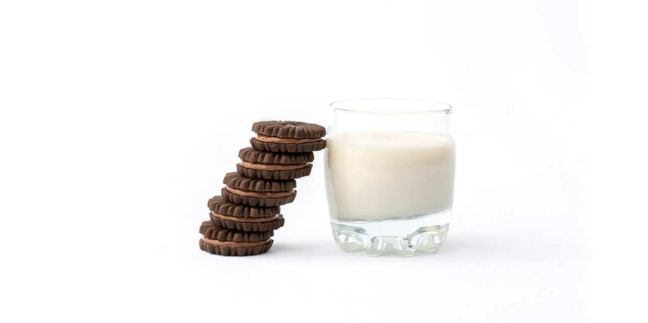 bolachas recheadas de chocolate junto a copo de leite