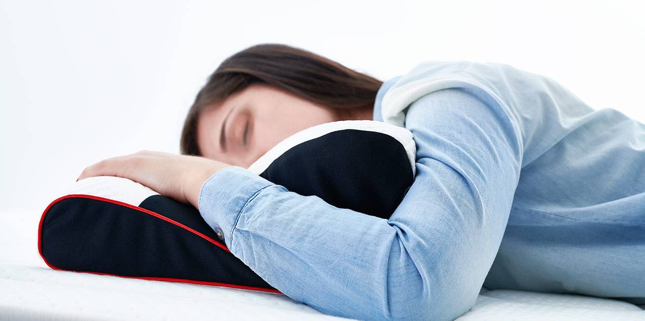 rapariga a dormir de barriga para baixo em almofada de viscoelástica