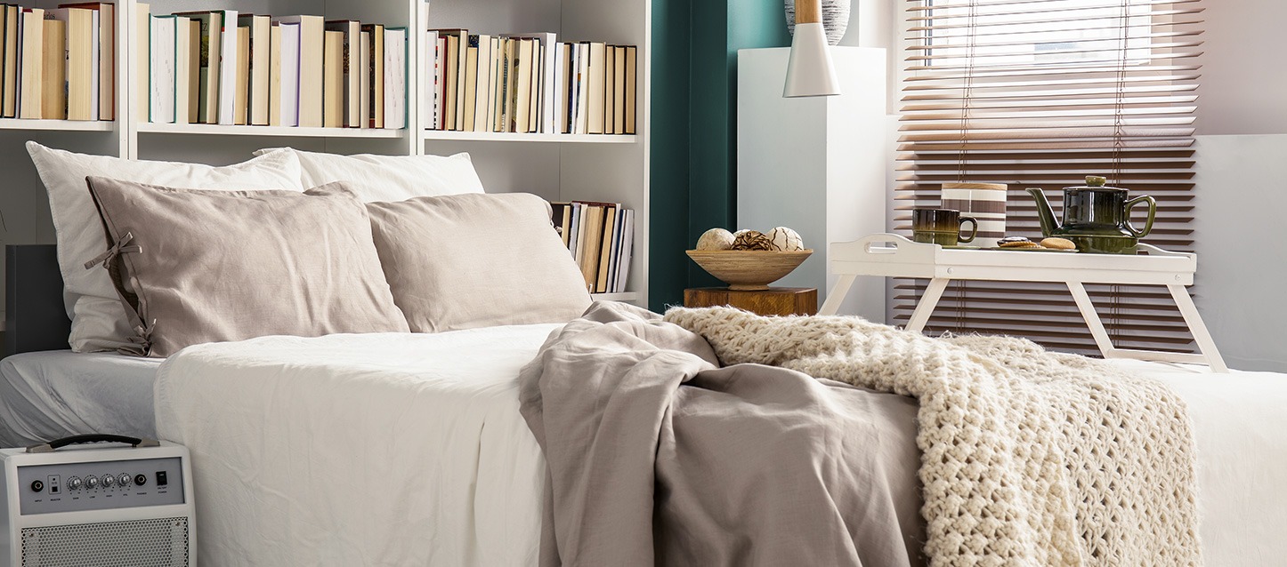 quarto de hóspedes com estantes com livros, amplificador, e mesa auxiliar com pequeno-almoço