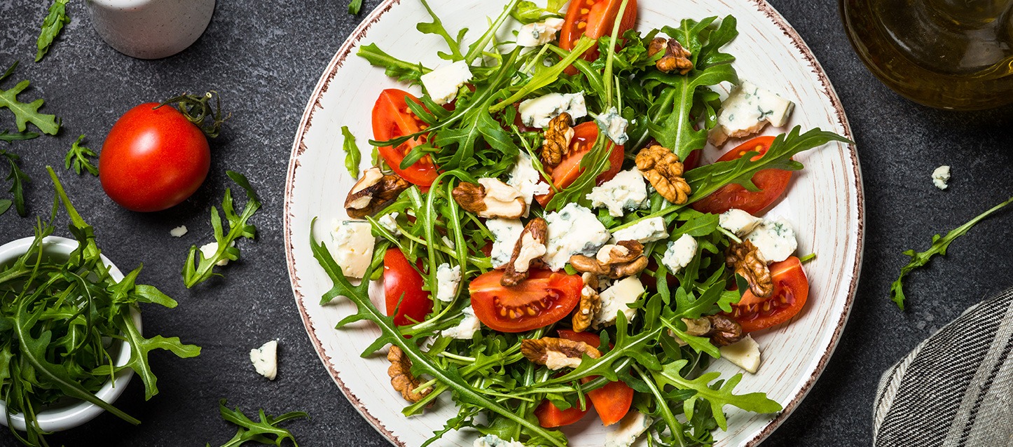 prato com salada de rúcula, tomate, queijo gorgonzola e nozes